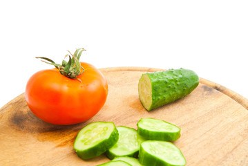 cucumber and tomato on wooden cutting board