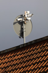 Kameras an einer Satellittenschüssel auf einem Dach