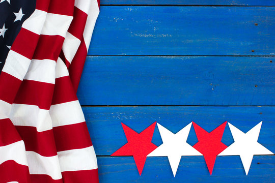American flag and red and white stars on blue wood background
