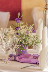 Premium dinner gala table with flowers napkins and glasses. High class arrangement for e.g. a wedding, birthday or business meeting