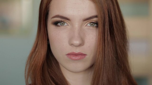 Young beautiful redhead woman shows an gorgeous evening smokey eyes makeup
