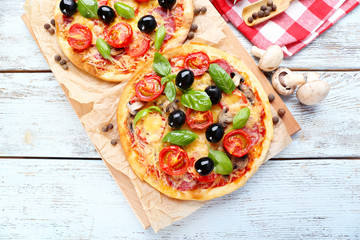 Tasty pizza with vegetables and basil on table close up