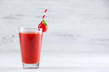 Glass of tomato juice with vegetable on wooden background