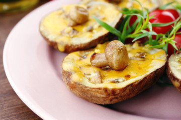 Baked potatoes with cheese and mushrooms on table close up