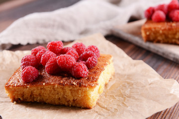 Fresh pie with raspberry on parchment on wooden table, closeup