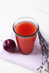 Delicious plum juice with fruits on wooden table close up
