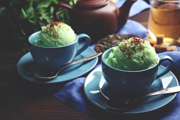 Homemade Green tea ice-cream in cup, on wooden background