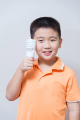 Asian boy holding a lamp, energy saving lamp,