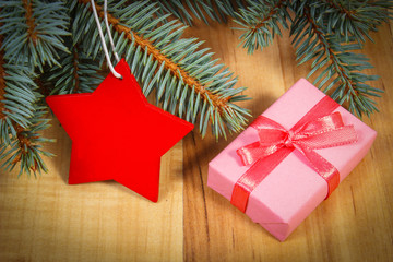 Spruce branches with red wooden star and gift for Christmas
