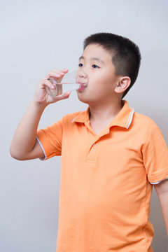 Asian boy drinking water from glass