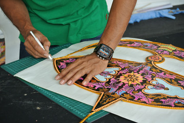 Malaysian kite maker working on a kite in his workshop