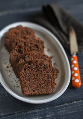 pieces of chocolate cake on the oval dish on dark wooden background
