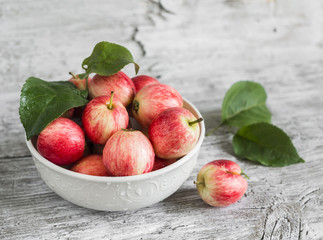 fresh apples in a white bowl on bright wooden surface