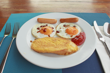 Easy breakfast with bread, fried egg and sausage in white dish