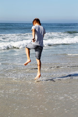 Fototapeta na wymiar boy jumping on the beach