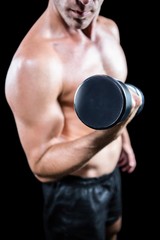 Fototapeta na wymiar Midsection of shirtless man working out with dumbbell