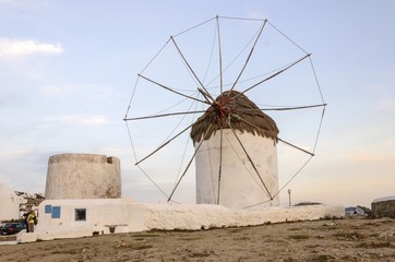 Fototapeta na wymiar A windmill in Chora,Mykonos,Greece at sunset.Traditional greek whitewashed architecture,popular landmark,tourist destination on the island of winds against blue sky. The wind mills are now decorative.