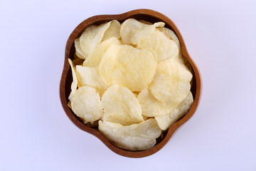 Crispy potato chips in wooden bowl isolated on white background