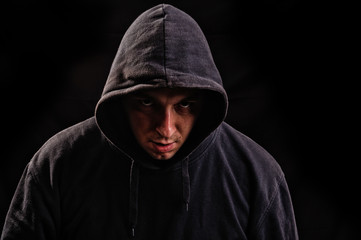 Naklejka na ściany i meble man with hoodie or hooligan over dark background