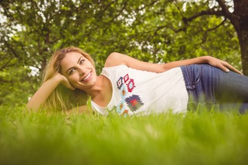 Naklejka na ściany i meble Cheerful woman relaxing on grass 