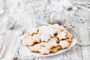 Christmas cookies and tinsel on a light wooden background