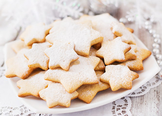 Christmas cookies and tinsel on a light wooden background
