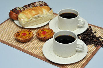 hot coffee with coconut tart and red bean bread on bamboo mat