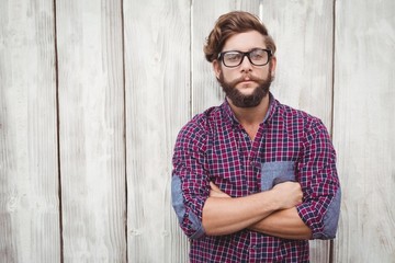 Confident hipster wearing eye glasses with arms crossed - obrazy, fototapety, plakaty