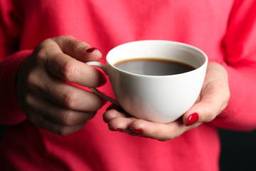 .   ..hot coffee in the Cup in the hands of the girl in the sweater