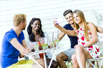 A group of friends sitting a table and talking smiling  while ta