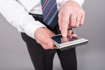 Businessman standing, using his smartphone