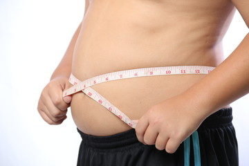 Fat boy measuring his belly with measurement tape