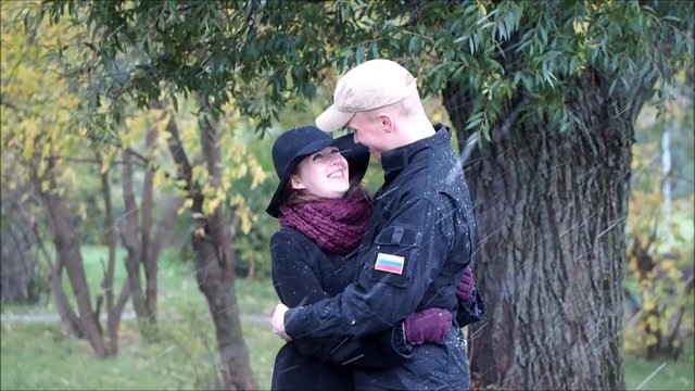 Осень. Первый снег. Парень обнимает девушку. Холодно, сильный ветер. Двое в парке. Эмоции, чувства, первая любовь 