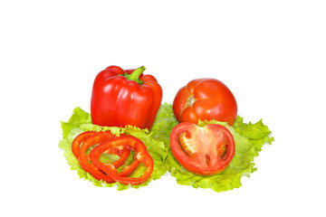 Red pepper and tomato with slices on lettuce leaves.