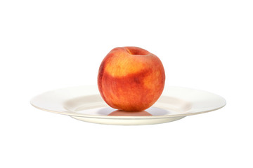Beautiful peach on a white plate close up.