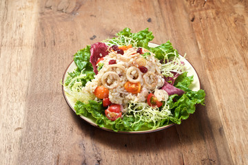 Plate of rice salad on wooden table