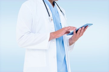 Composite image of male doctor using tablet 