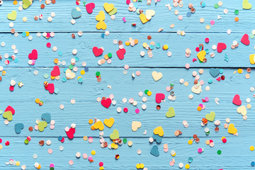 Blue wood background with scattered party confetti