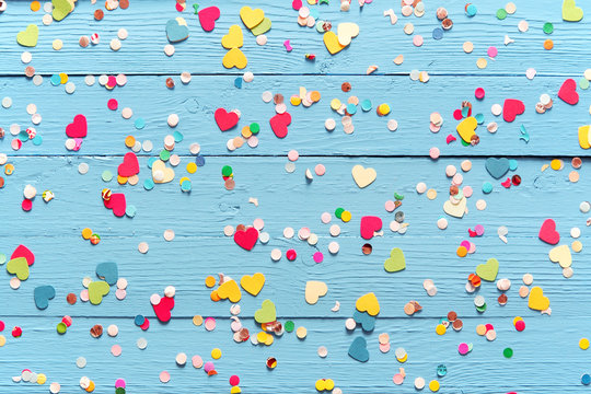 Blue wood background with scattered party confetti