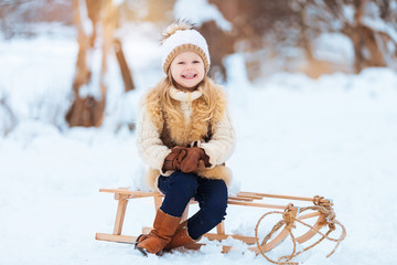 Little girl enjoying a day out playing in the winter forest