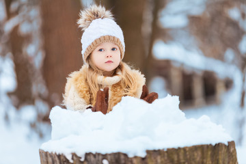 Little girl enjoying a day out playing in the winter forest