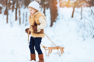 Little girl enjoying a day out playing in the winter forest