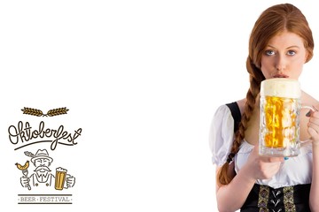 Composite image of oktoberfest girl drinking jug of beer