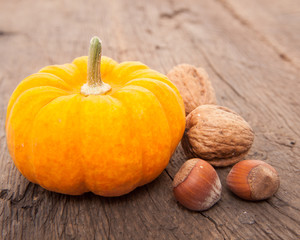 Pumpkin next to walnuts and hazelnuts