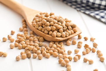 uncooked chickpeas on wooden spoon