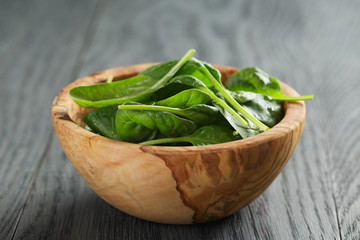 fresh spinach leaves in wooden bowl