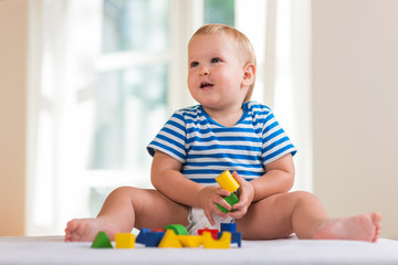 child boy playing with wooden toy blocks