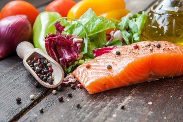 fresh salmon with vegetables on a wooden table