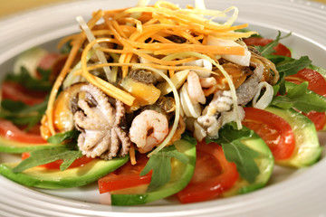 seafood salad decorated with tomatoes and green sweet pepper