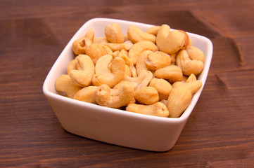 Cashew nuts on bowl on wooden table